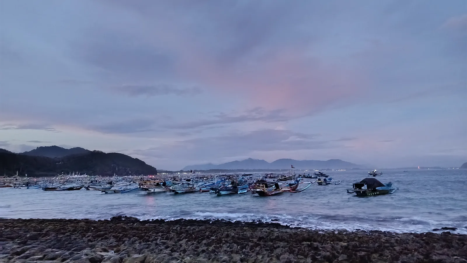Kumpulan perahu jukung nelayan beristirahat di bibir pantai pasir putih