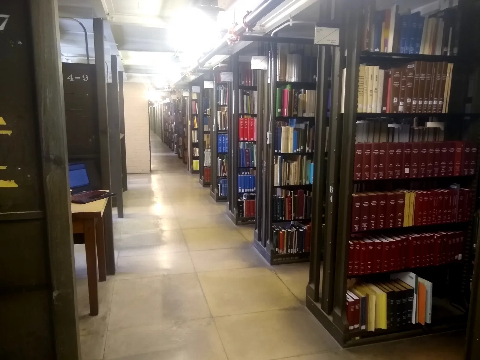 Deretan rak buku referensi dan literatur ilmiah di perpustakaan universitas